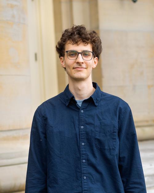 A color photo of a man smiling for a photo.
