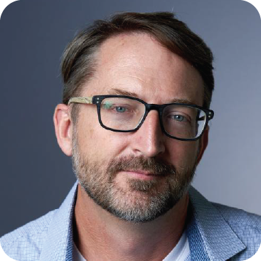 A color photo of a man with glasses.