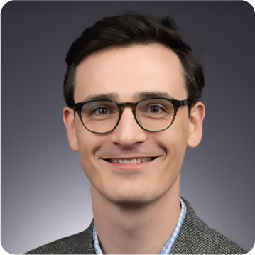 A color photo of a man with glasses.