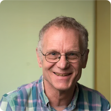 A color photo of a man with glasses.