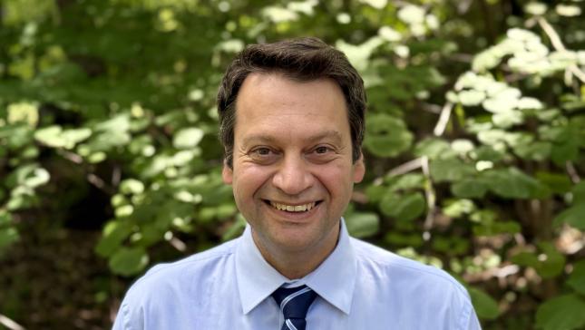 Sorin Lerner smiling at camera in blue shirt and tie