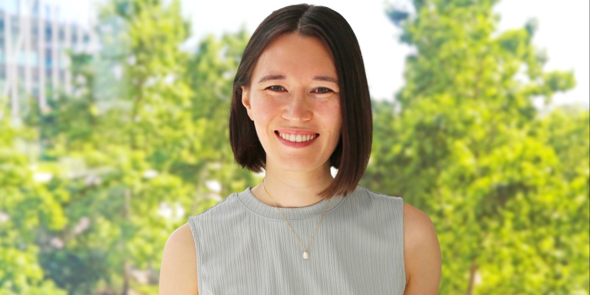 A color photo of a woman smiling for a photo.