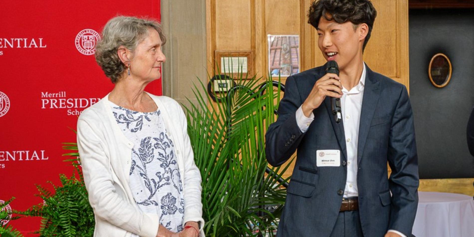 Minnue Uhm, right, speaks to attendees at the 37th Annual Merrill Presidential Scholars Luncheon about his high school Spanish teacher, Penelope Pendergrast, left.