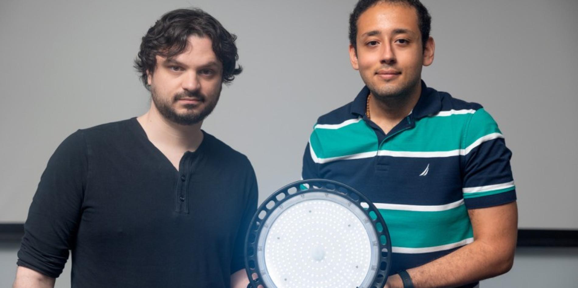Abe Davis, left, assistant professor of computer science in the Cornell Ann S. Bowers College of Computing and Information Science, and graduate student Peter Michael with a watermark light.