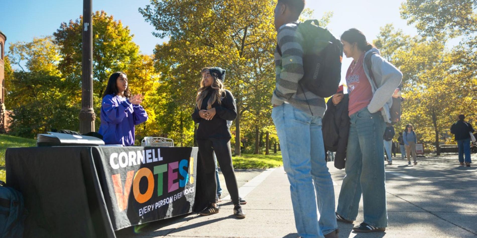 Students from the Cornell Policy Group, a nonpartisan student organization, help others register to vote on Ho Plaza.