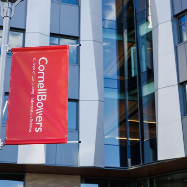 A color photo showing a red banner with the Cornell Bowers logo in white.