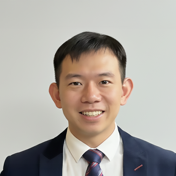 A color photo of a man wearing a suit and tie.