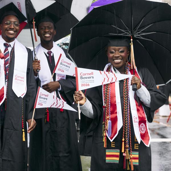 a group of black graduates smile under their umbrellas during the procession