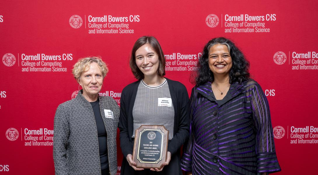 Three woman stand in front of red step and repeat