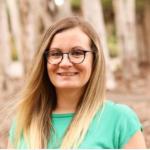 Color portrait of woman smiling at camera, long blonde hair, glasses