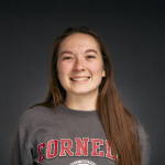 A color photo of a woman smiling for a photo.