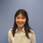 A color photo of a woman smiling for a photo.