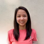 A color photo of a woman smiling for a photo.