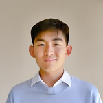 A color photo of a man smiling for a portrait.