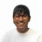 A color photo of a man smiling for a portrait.