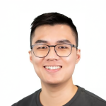 A color photo of a man smiling for a portrait.