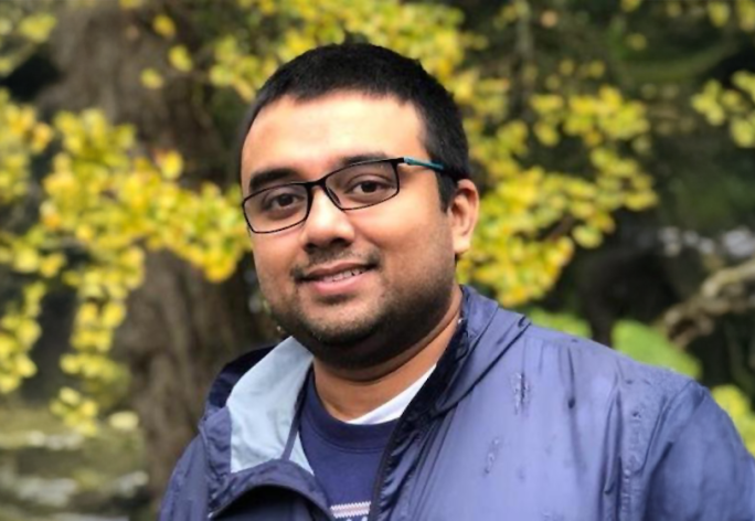 A color photo of Tapomayukh Bhattacharjee, a man with glasses, short dark hair and gray jacket