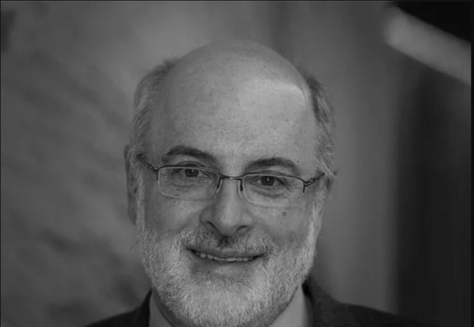 A black and white photo of Kenneth Birman, a man with glasses wearing a suit and tie.