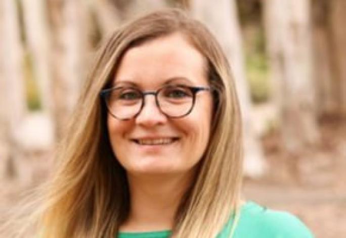 Color portrait of woman smiling at camera, long blonde hair, glasses
