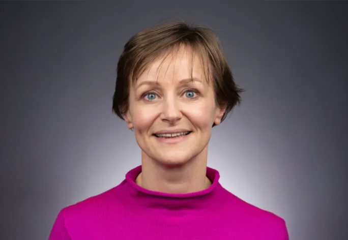 A photo of Anke van Zuylen, a woman with short brown hair in a pink shirt.
