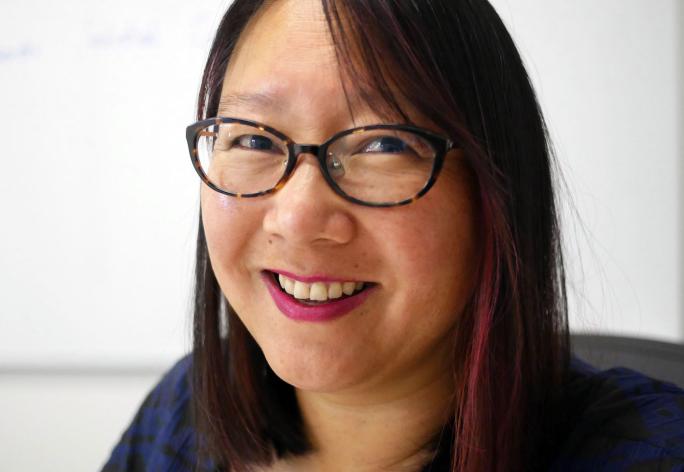 Woman in glasses smiling at camera, 