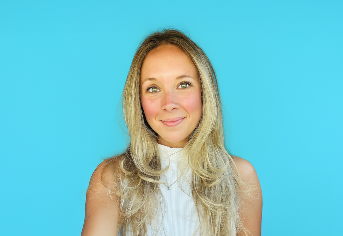 A color photo of a woman smiling for a photo.