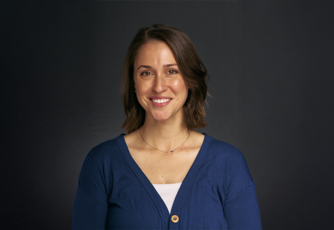 A color photo of a woman smiling for a photo.