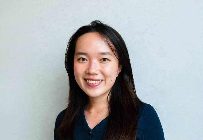 A color photo of a woman smiling for a photo.