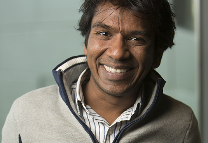 The head and shoulder of a man with black hair and a gray fleece.