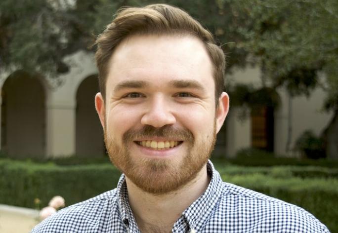Color portrait Preston Culbertson smiling at the camera; short brown hair wearing checker shirt