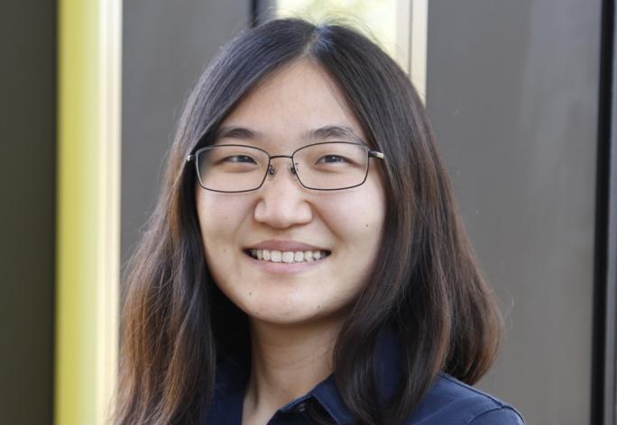 A photo of Jennifer J. Sun, a woman with long dark hair, glasses and a blue shirt