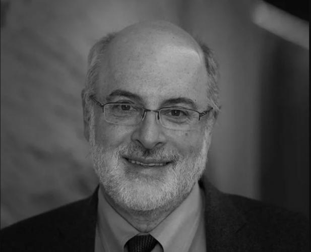 A black and white photo of Kenneth Birman, a man with glasses wearing a suit and tie.