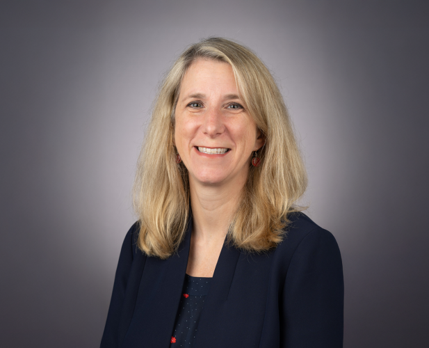 A color photo of Laura Batten in front of a grey background