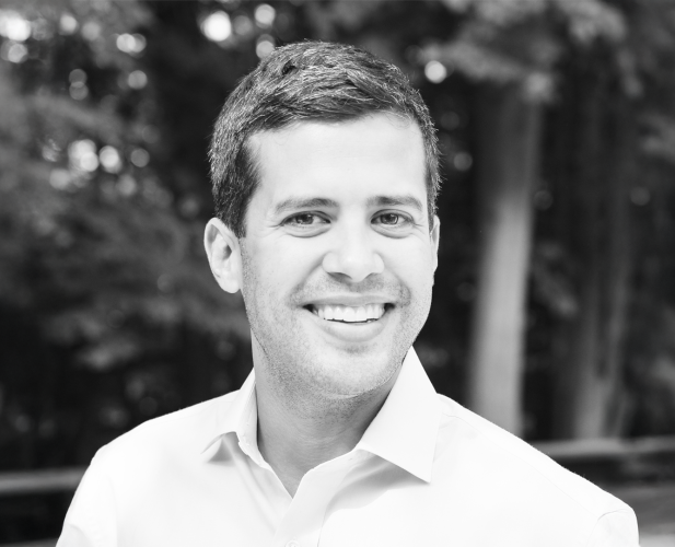 A black and white photo of Ryan Marchenese standing outside