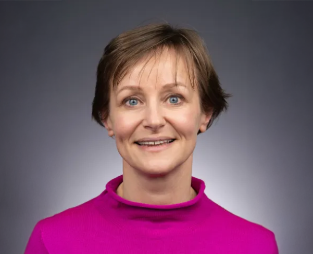 A photo of Anke van Zuylen, a woman with short brown hair in a pink shirt.