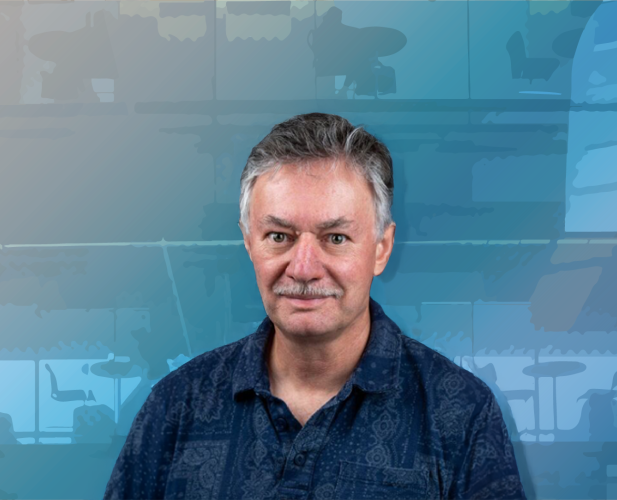 A color photo of James Booth in front of an abstract blue background