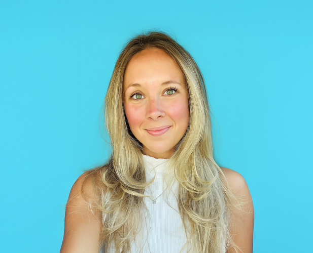 A color photo of a woman smiling for a photo.