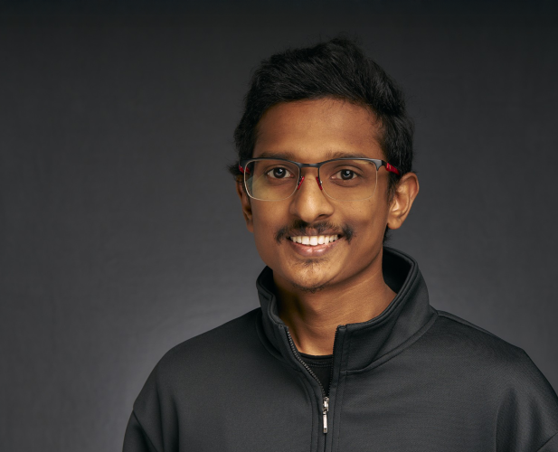 A color photo of a man with glasses.