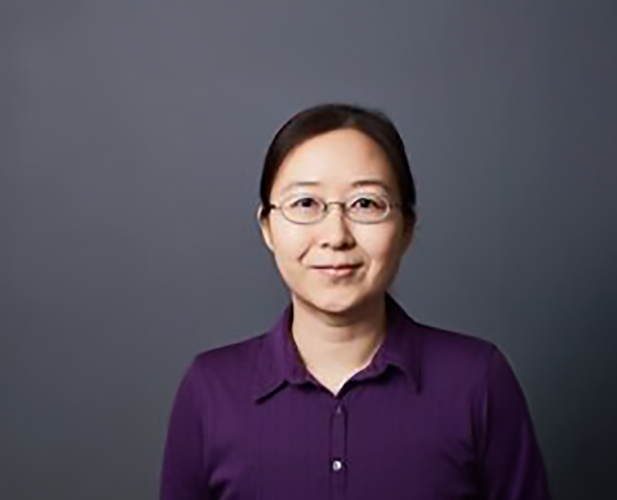 A color photo of a woman smiling for a photo.
