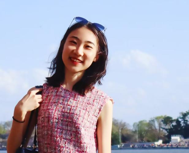 A color photo of a woman smiling for a photo.