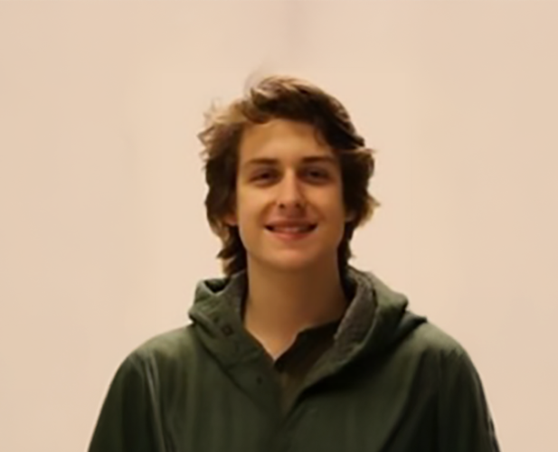 A color photo of a man smiling for a portrait.