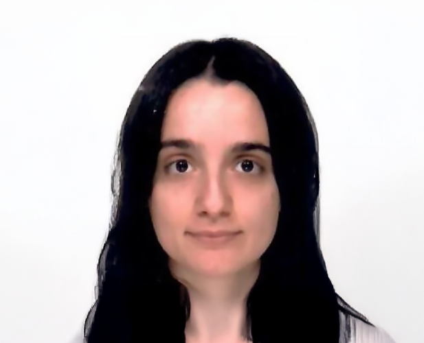 A color photo of a woman smiling for a photo.