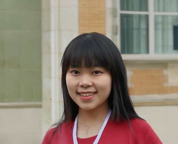 A color photo of a woman smiling for a photo.