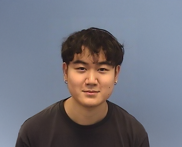 A color photo of a man smiling for a portrait.