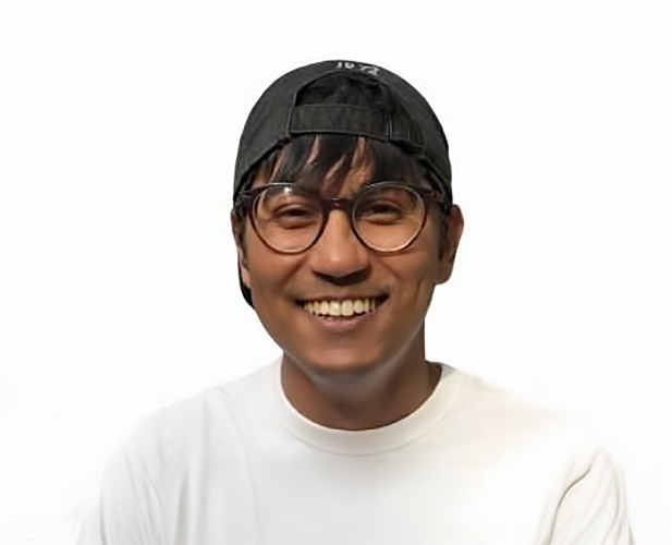 A color photo of a man smiling for a portrait.