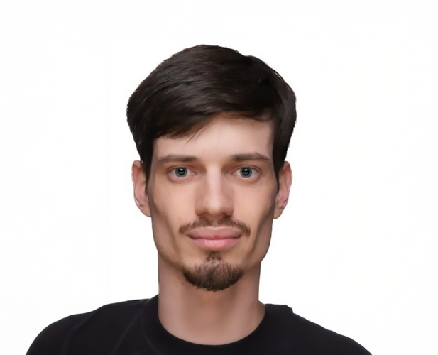 A color photo of a man smiling for a portrait.