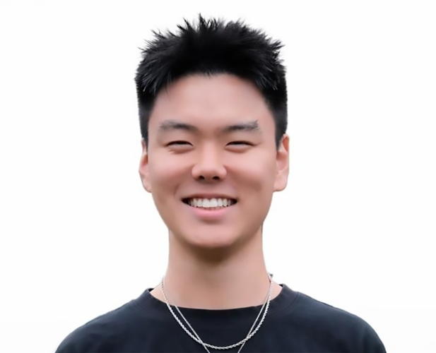 A color photo of a man smiling for a portrait.