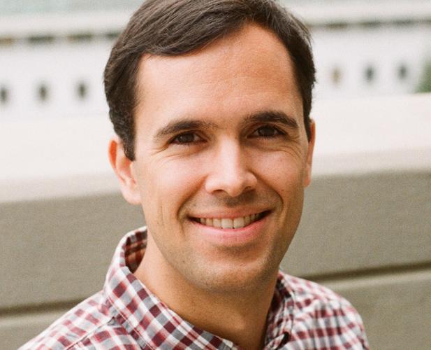 A photo of Anil Damle, a smiling man with brown hair and a red and white checked shirt.