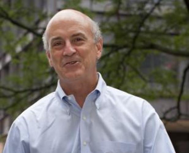 color photo of man in dress shirt smiling