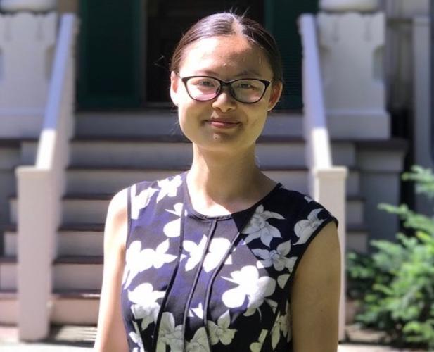 portrait of woman with hair pulled back and glasses, flower print dress